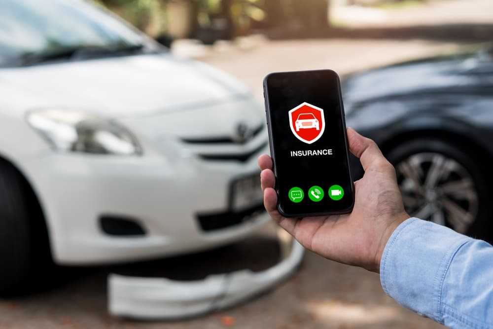 .Man using phone to calling insurance agent for claim process after car crash