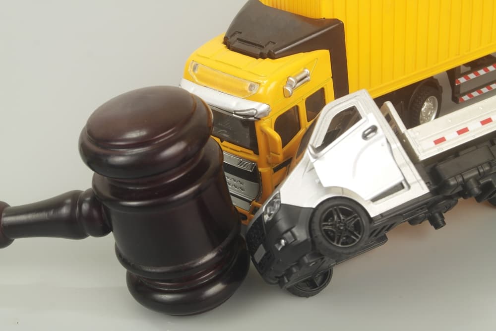 Judge gavel and container carrier hits truck on grey background.